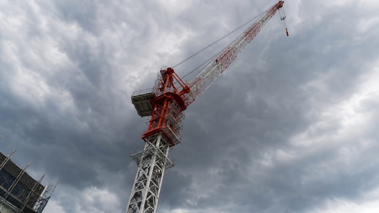 雷雲が広がる空にそびえる建設現場のクレーン｜周囲より高い構造物の落雷リスク